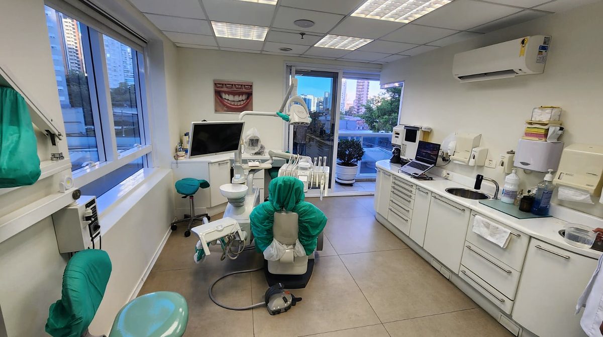 Sala de atendimento com duas janelas amplas e vista da cidade